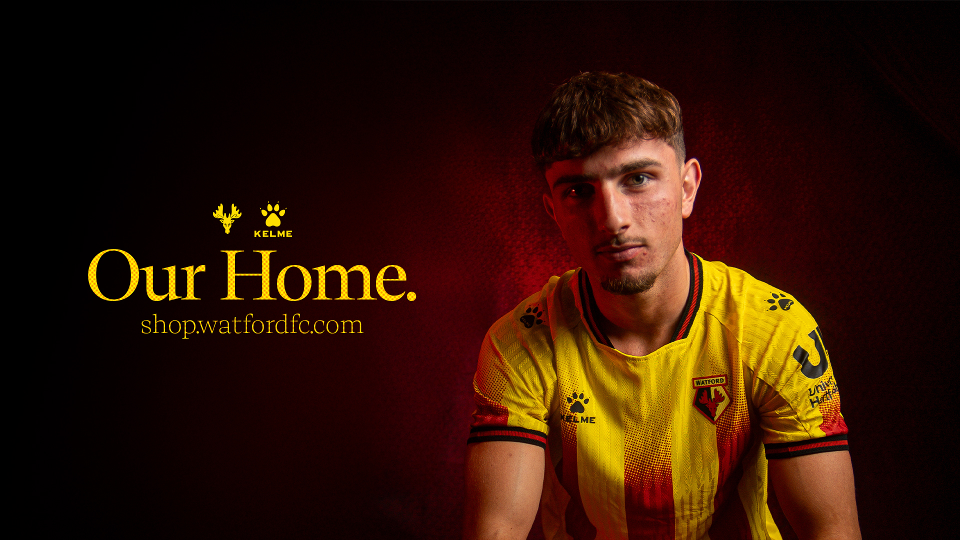 Football player, Rocco Vata, wearing a yellow and red Watford FC jersey against a dark red background with the text 'Our Home. shop.watfordfc.com'.