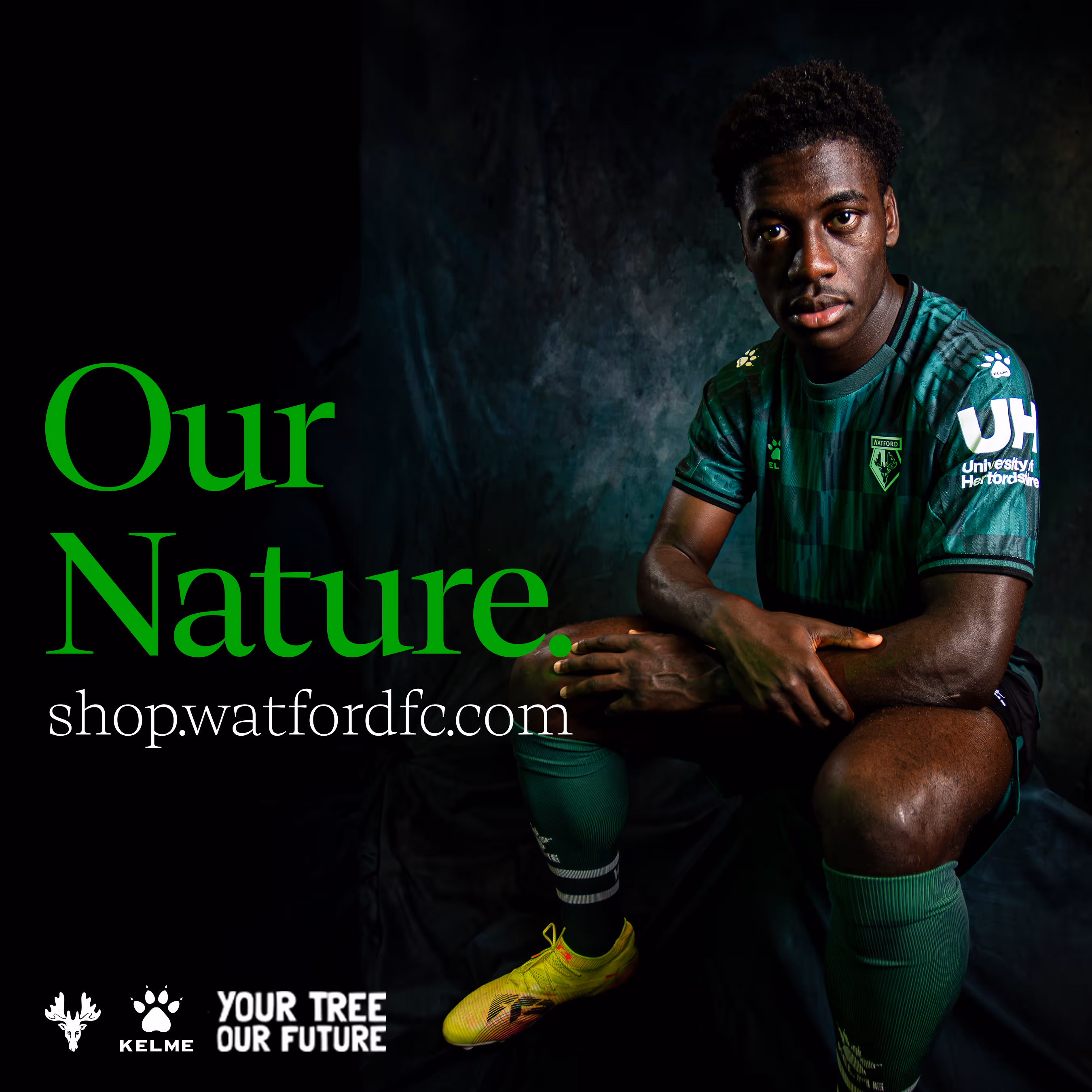 Football player, James Abankwah, wearing green Watford FC jersey sitting with arms crossed against a dark background with text 'Our Nature' and website shop.watfordfc.com.
