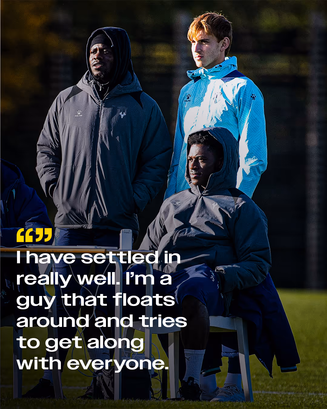 Three Watford players outdoors wearing hooded jackets and sportswear, with a quote overlay about settling in and getting along with everyone.