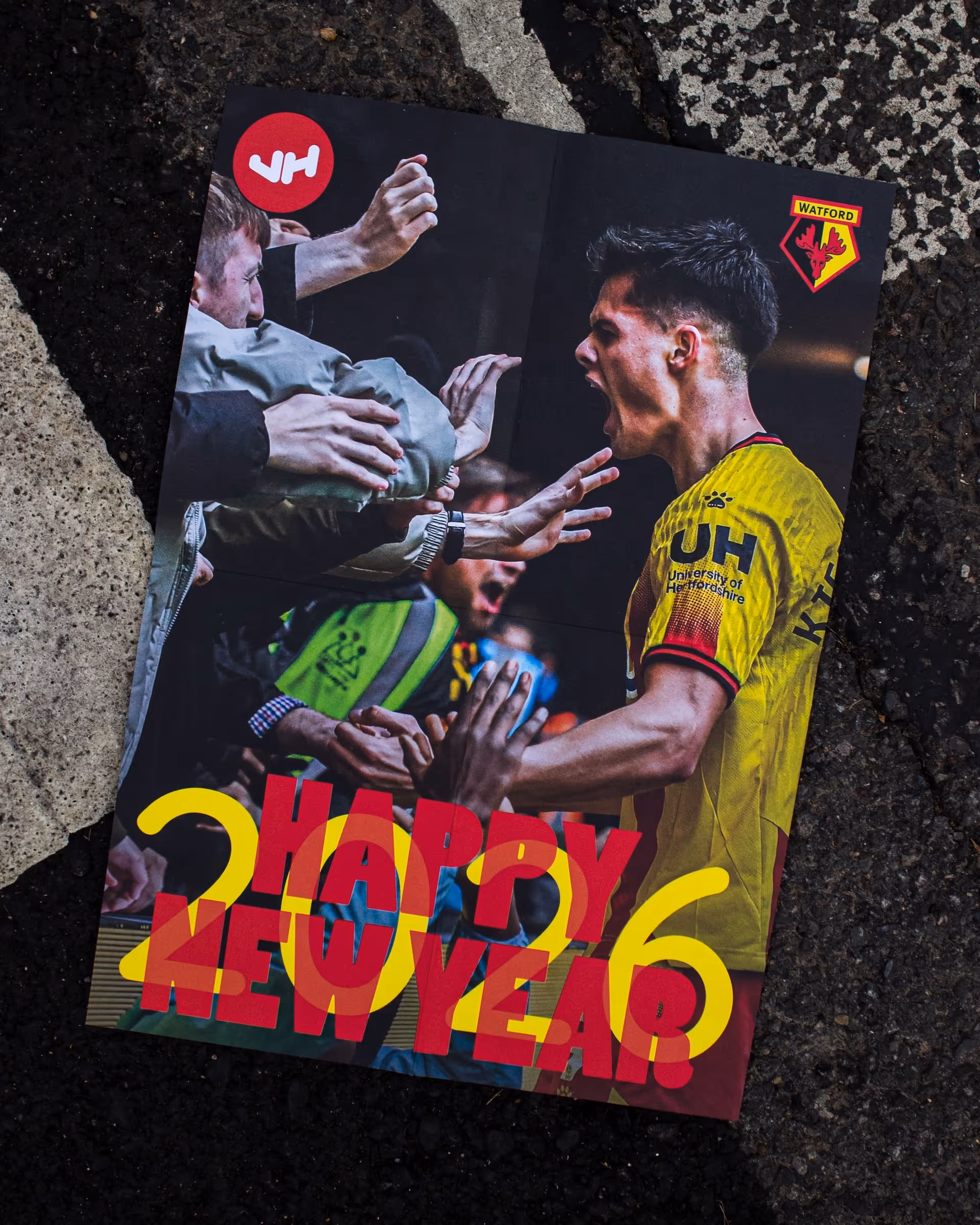 Football player Luca Kjerrumgaard in yellow jersey celebrating with fans reaching out under Happy New Year 2026 text.