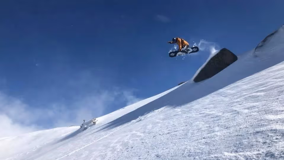 A Man Flying Through The Air While Riding A Snowboard