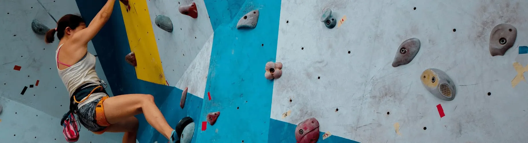 A Person Climbing Up The Side Of A Climbing Wall