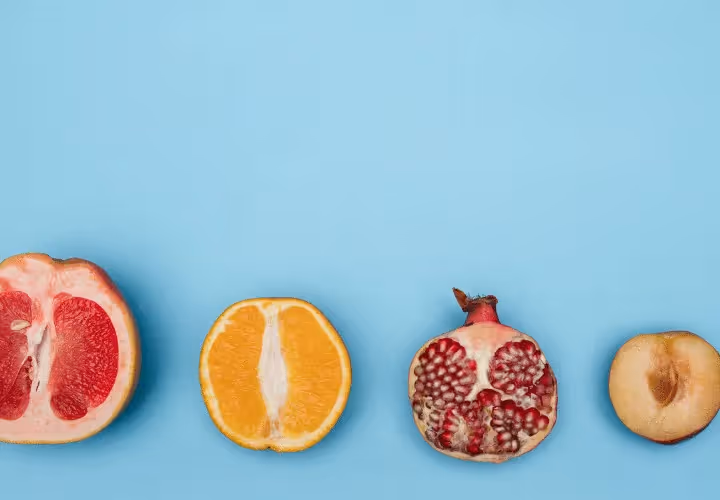 A Group Of Fruit Cut In Half On A Blue Background