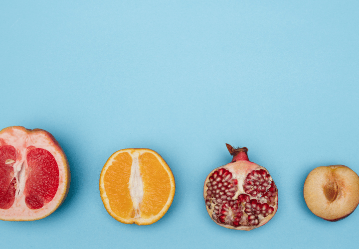 A Group Of Fruit Cut In Half On A Blue Background