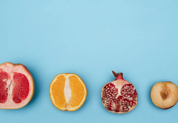 A Group Of Fruit Cut In Half On A Blue Background