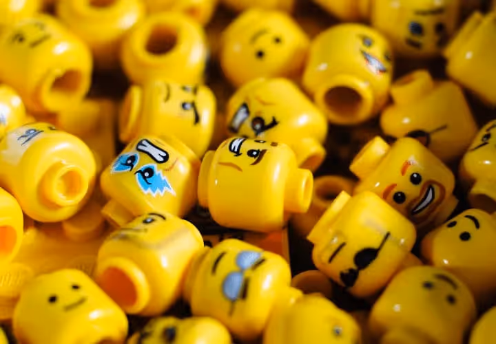 A Bunch Of Yellow Legos With Faces On Them.