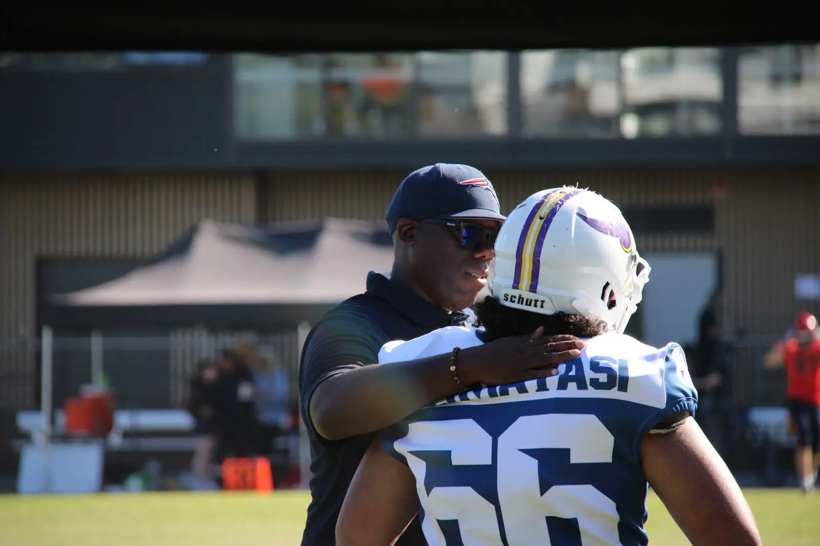 Coach motivates player 66 on the sideline during a game.