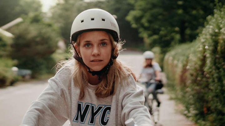 Kids Riding A Bike Down A Street