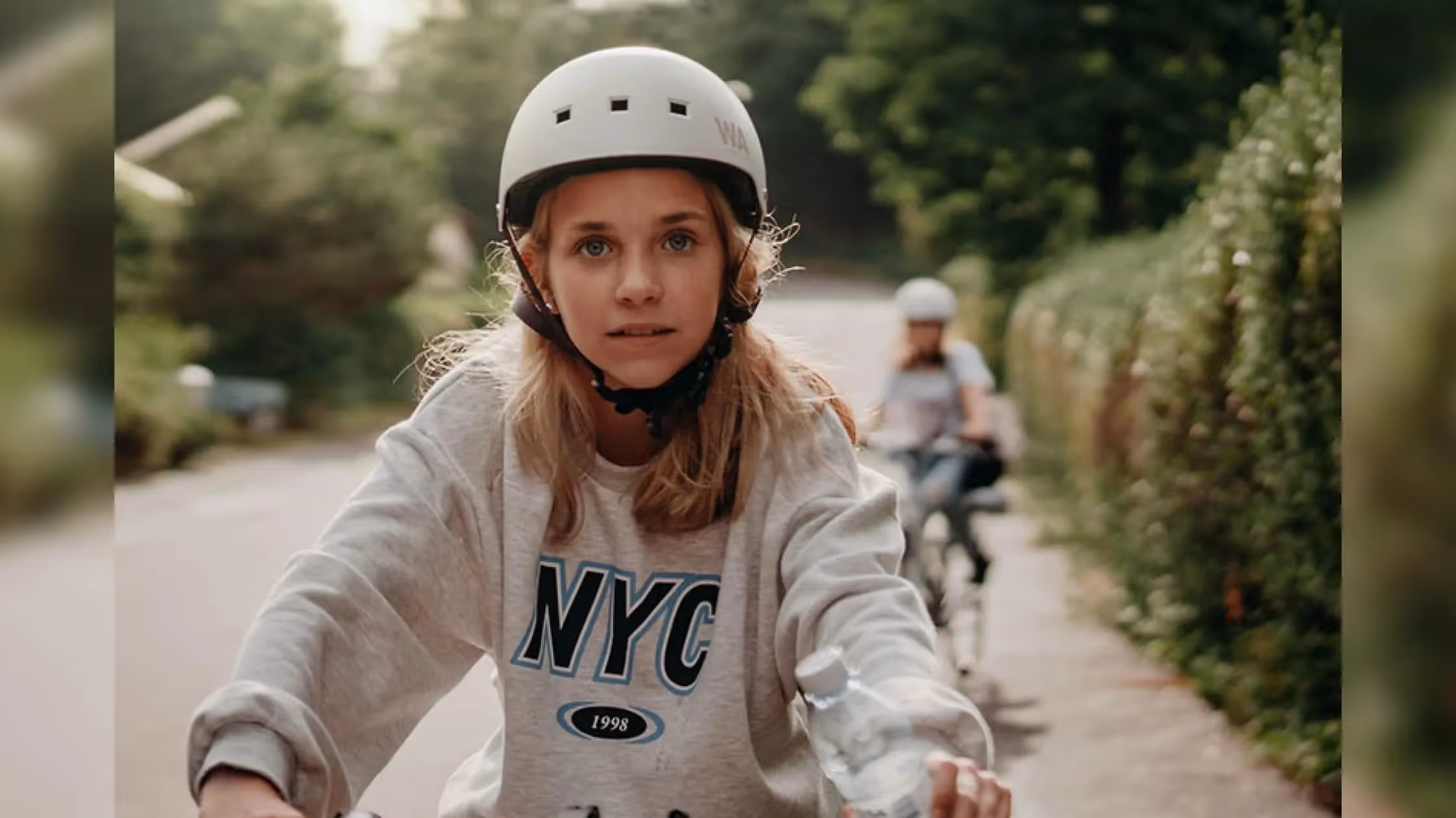 Kids Riding A Bike Down A Street