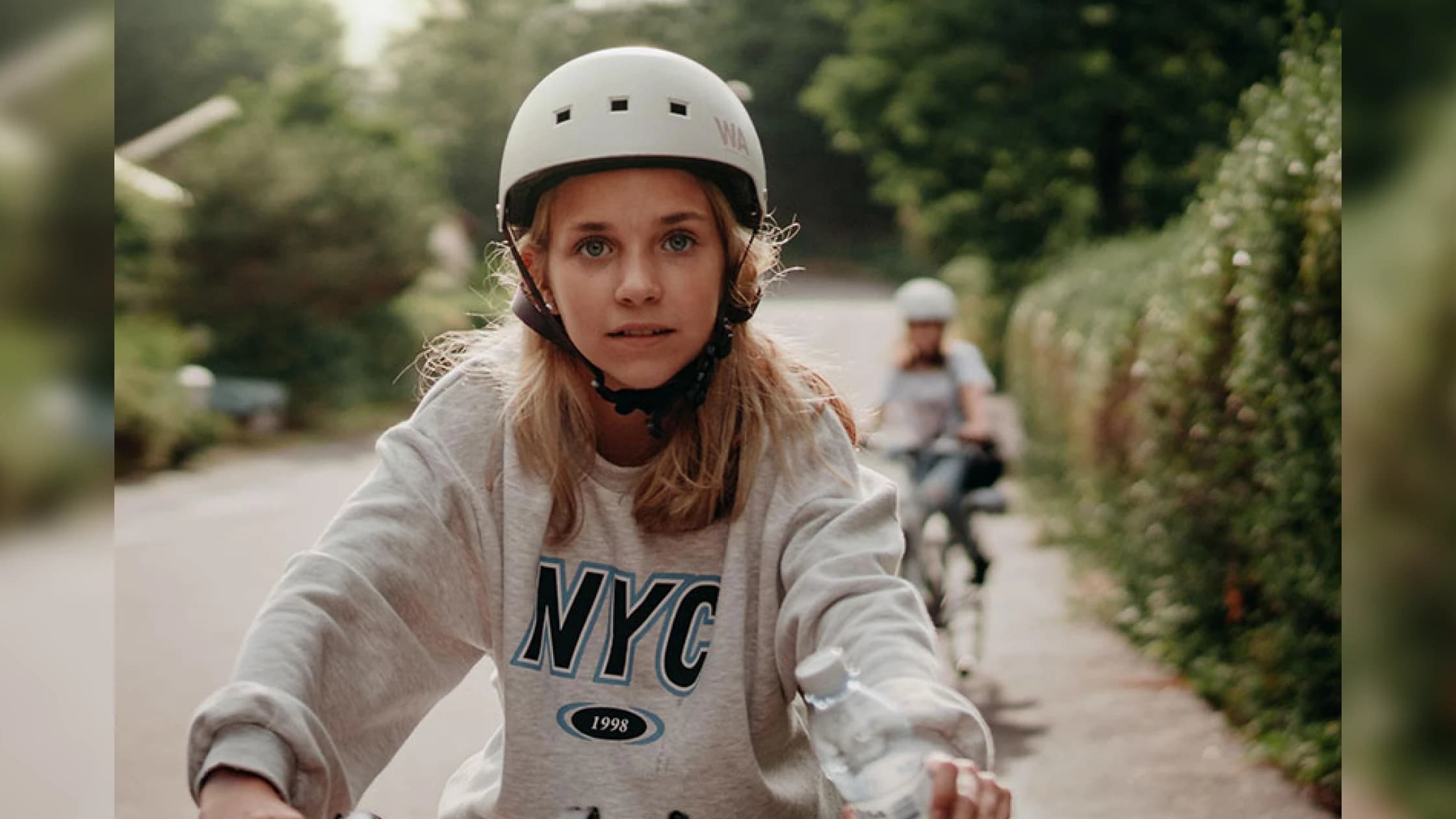 Kids Riding A Bike Down A Street