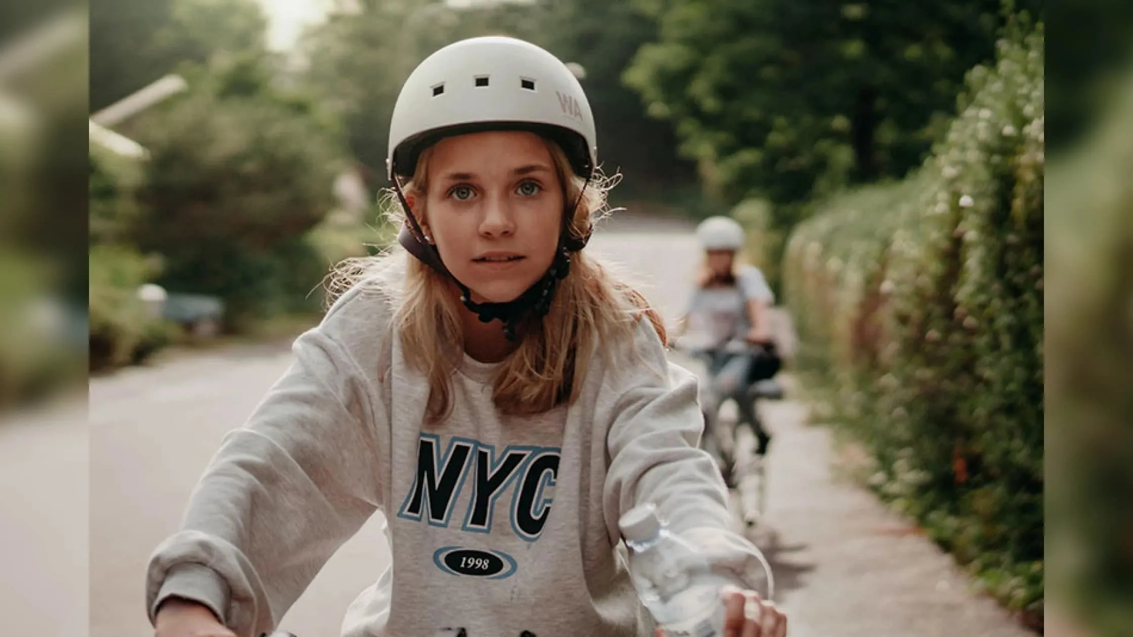 Kids Riding A Bike Down A Street