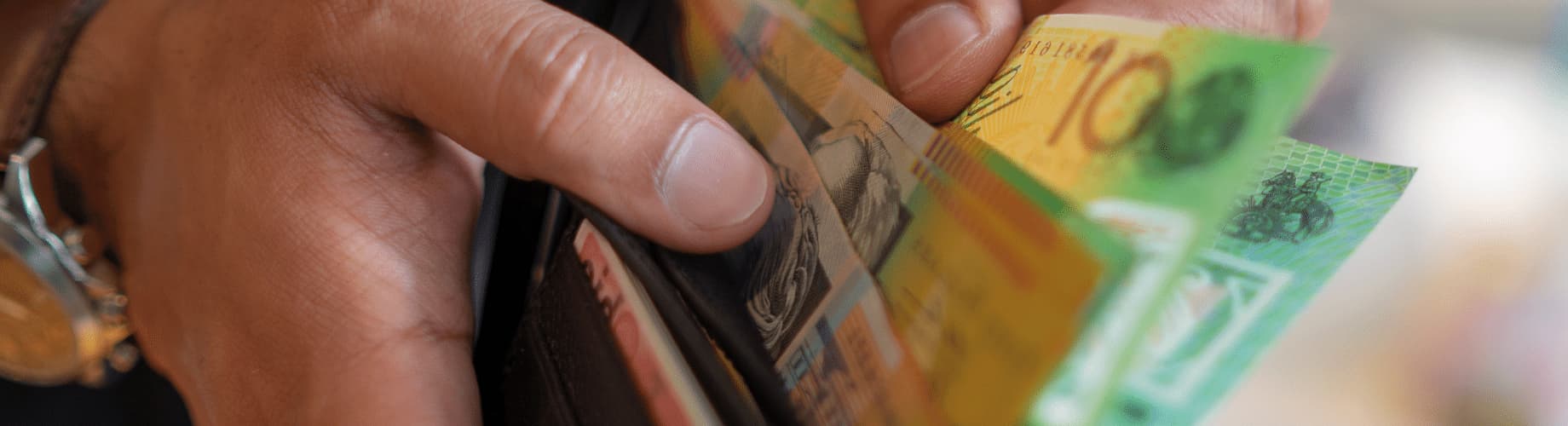 A Person Holding A Wallet With Money Sticking Out Of It