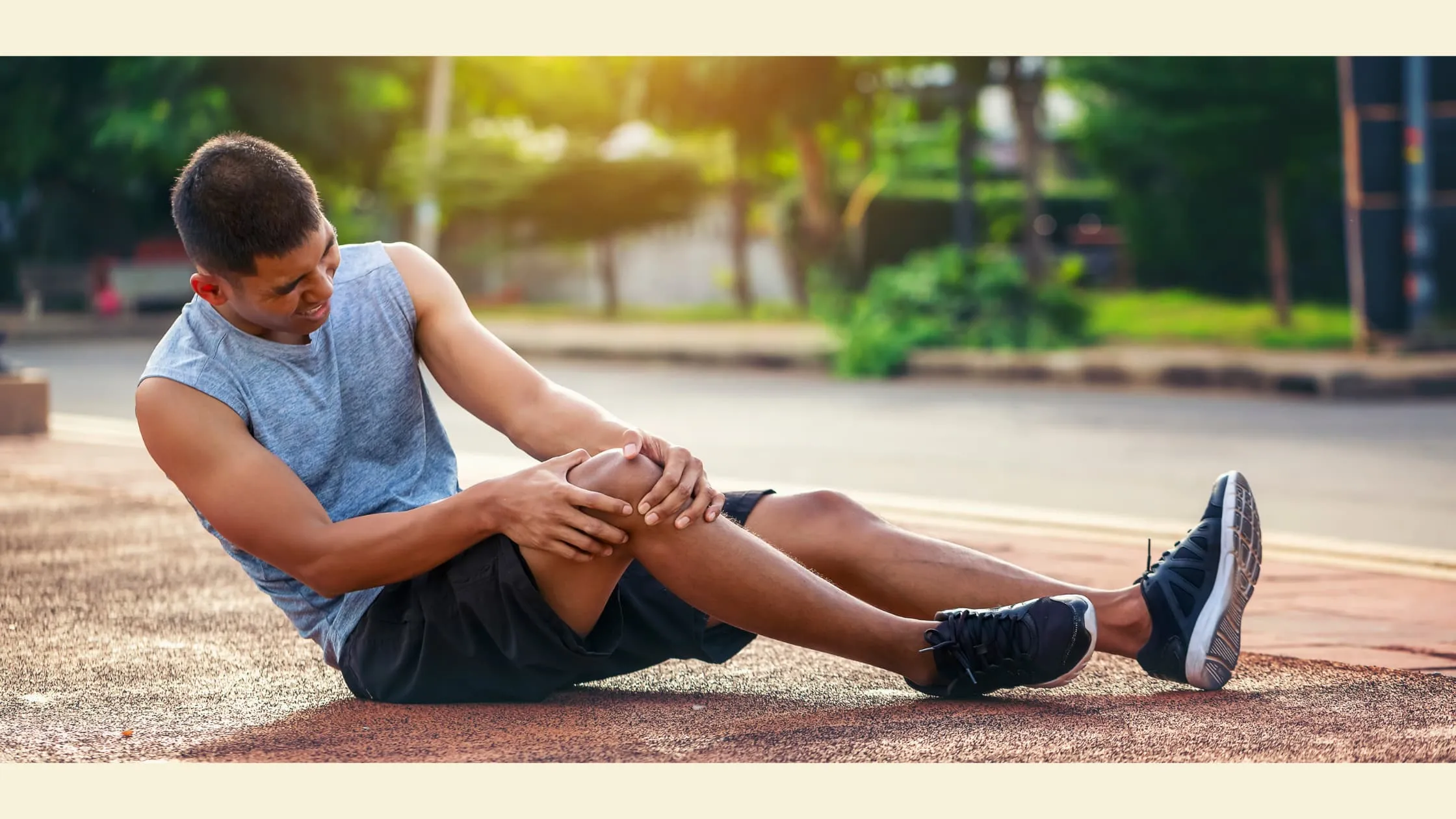 A Man Sitting On The Ground With His Knee In Pain