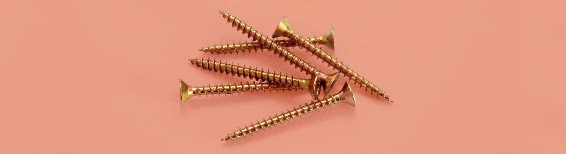 A Group Of Screws On A Pink Background