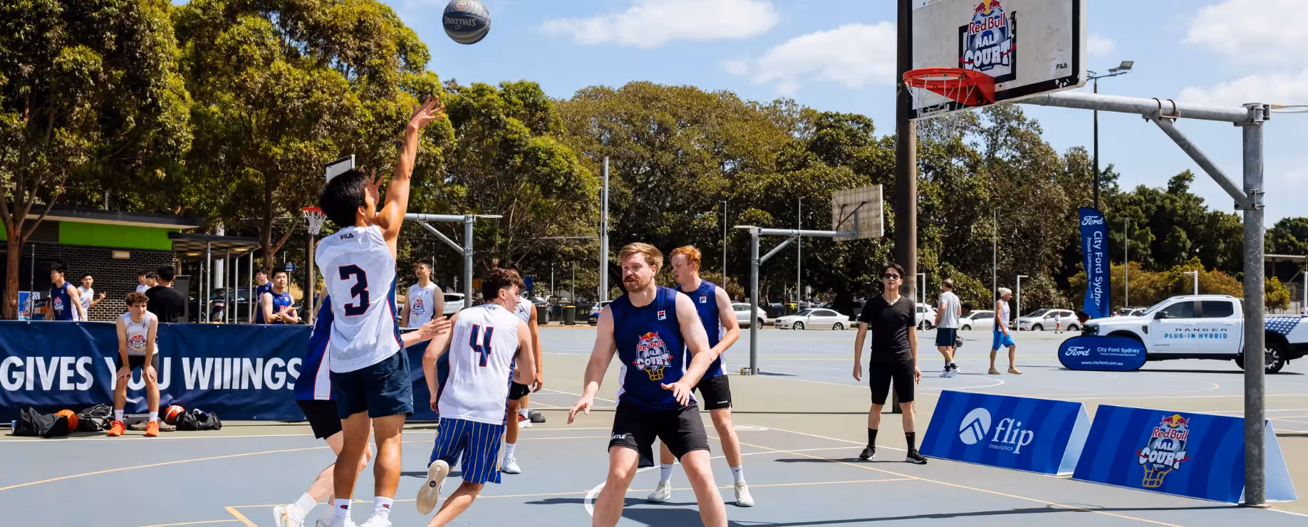 Players competing in an outdoor 3x3 basketball tournament on a sunny day
