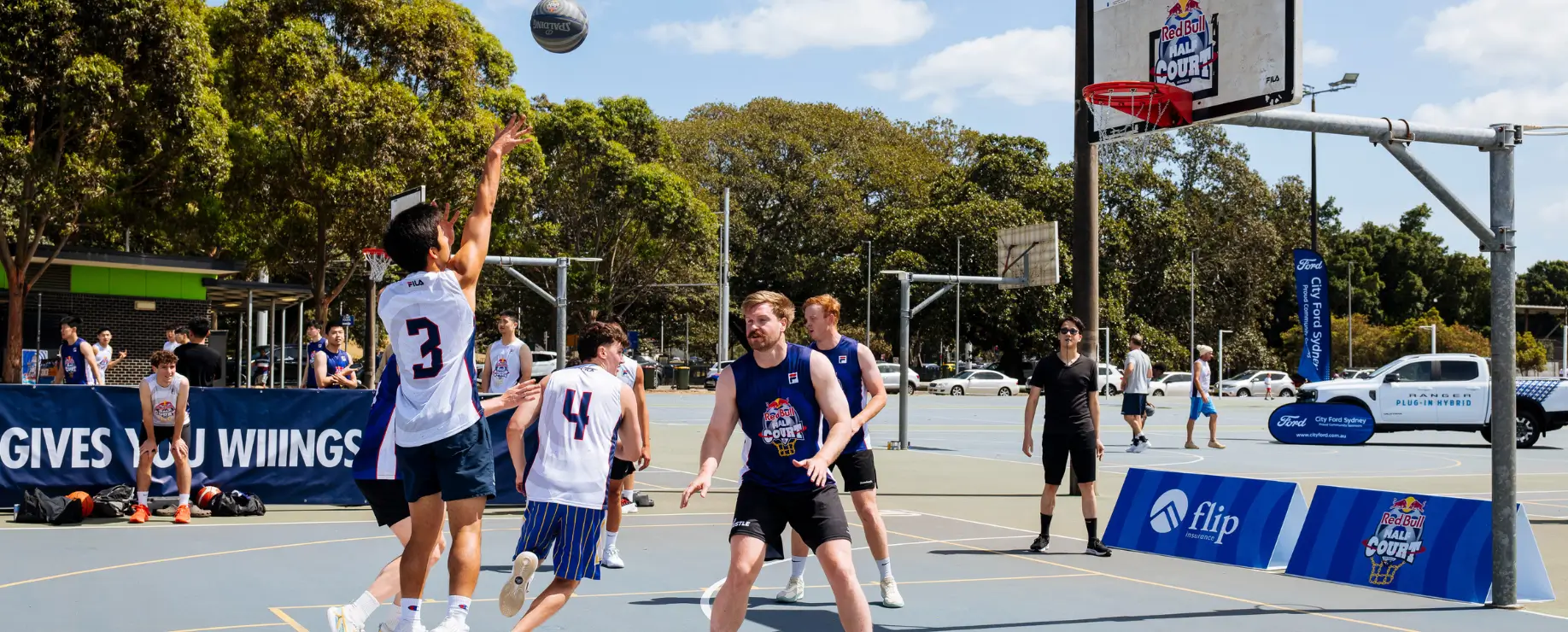 Players competing in an outdoor 3x3 basketball tournament on a sunny day