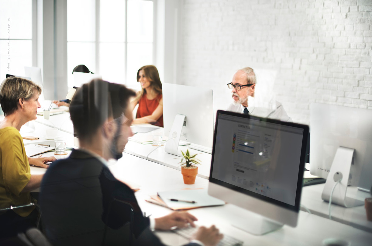 Das Bild zeigt einen moderen Büroarbeitslatz, an dem Mitarbeitendene am Computer arbeiten. Diese Umgebung ist ideal für die Netzwerkanalyse.