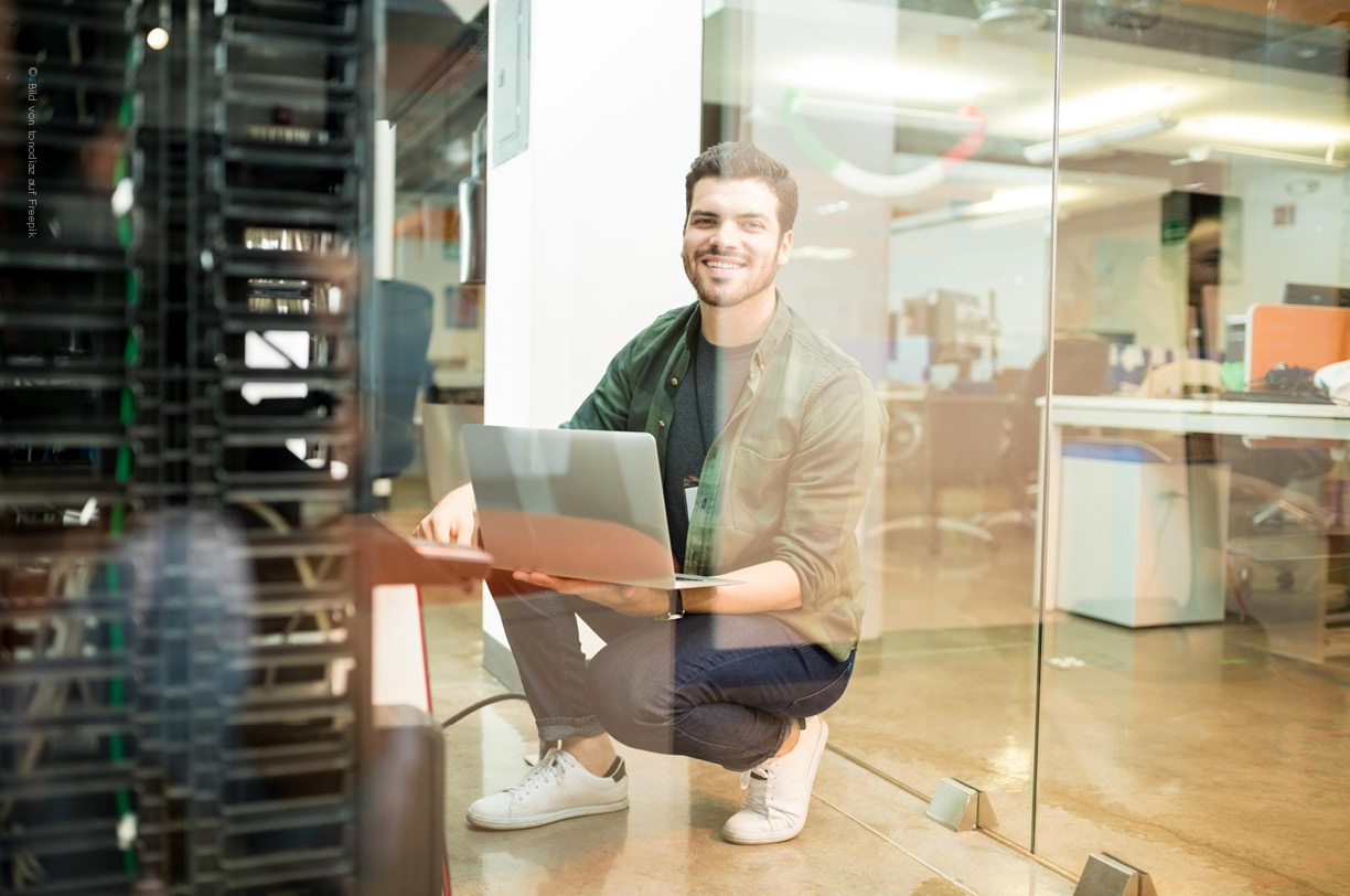 Ein IT-Experte untersucht Netzwerkkabel und -geräte an einem Serve, um die Netzwerkleistung zu überwachen.