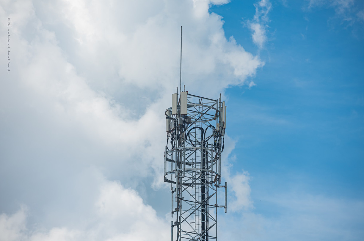Ein Mobilfunkmast mit 5G-Antennen steht in einer städitischen Umgebung, um eine schnelle Datenübertragung für lokale und weitreichende Netzwerke zu ermögliche