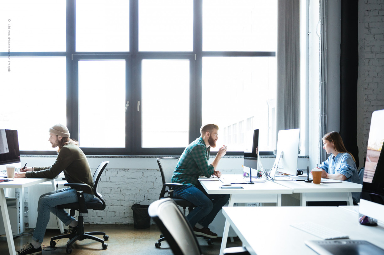 Ein modernes Büro mit vernetzten Arbeitsplätzen, an denen mehrere Computer stehen. Die Arbeitsstationen sind so gestaltet, dass sie eine effiziente Kommunikation und Zusammenarbeit innerhalb eines lokalen oder weitverkehrsnetz (WAN) ermöglichen