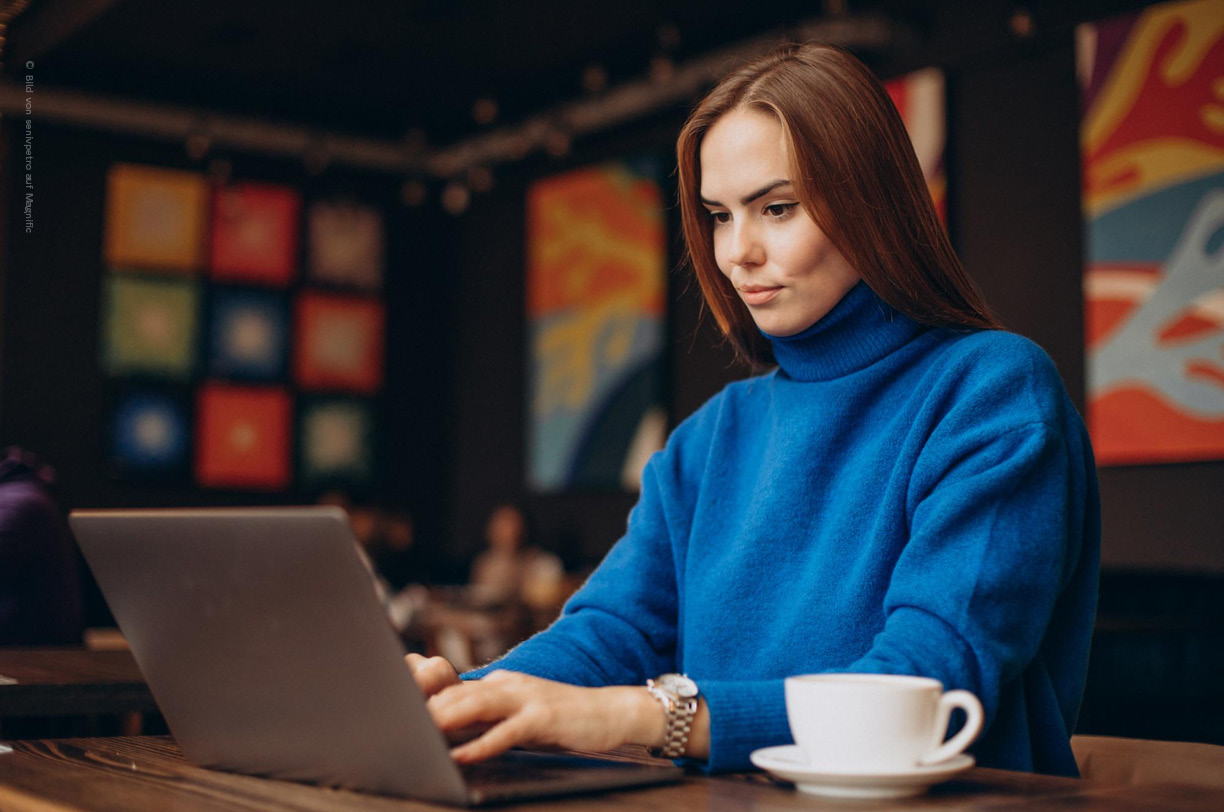Eine Frau arbeitet hochkonzentriert an einem Laptop, während eine Kaffeetasse neben ihr auf dem Tisch steht. Die Umgebung strahlt eine produktive Atmosphäre aus, die ideal für die Umsetzung von Sicherheitsstrategien wie dem Zero Trust Ansatz ist.