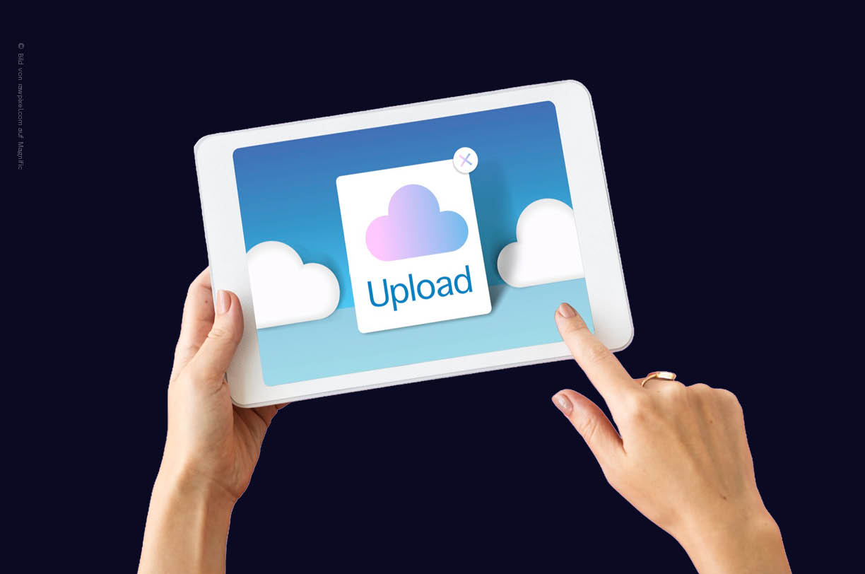 Frauenhände halten ein weißes Tablet. Auf dem Bildschirm ist ein Cloud-Symbol mit dem Hinweis Upload zu sehen. Dies symbolisiert die digitale Zusammenarbeit und die Dateiablage in der Cloud für Unternehmen.