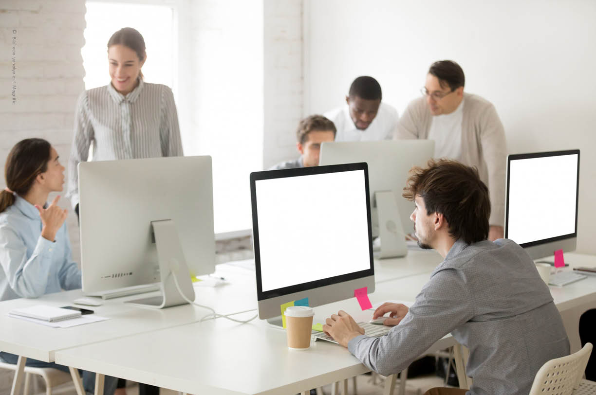 In einem modernen Büro arbeiten Mitarbeitende konzentriert an ihren Arbeitsplätzen, umgeben von Monitoren. Die IT-Infrastruktur unterstützt sie im Arbeitsalltag, während IT-Probleme im Hintergrund gelöst werden.