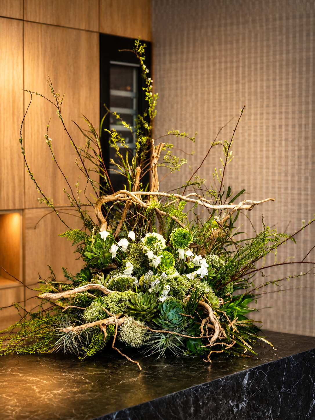 Driftwood counter installation with flowers growing from its crevices and settled succulents