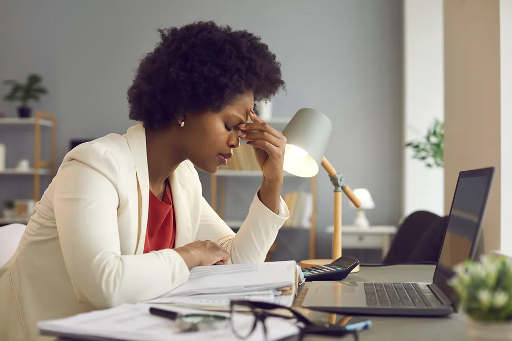 Exhausted employee asleep at their desk — burnout caused by an always-say-yes customer culture