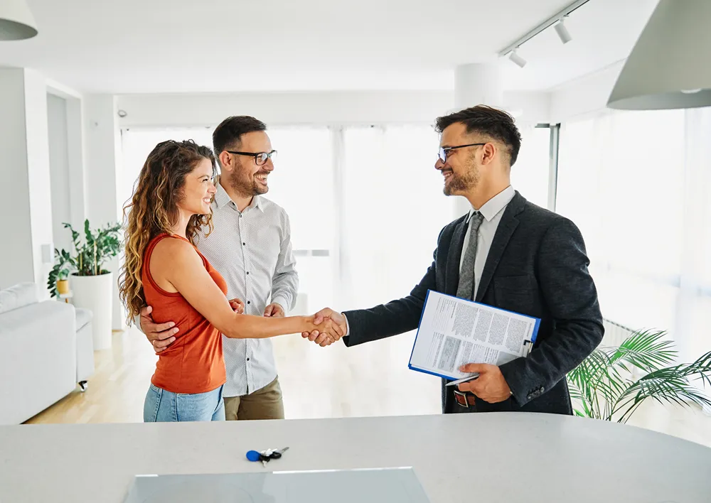 Real estate professionals networking and shaking hands at an industry event