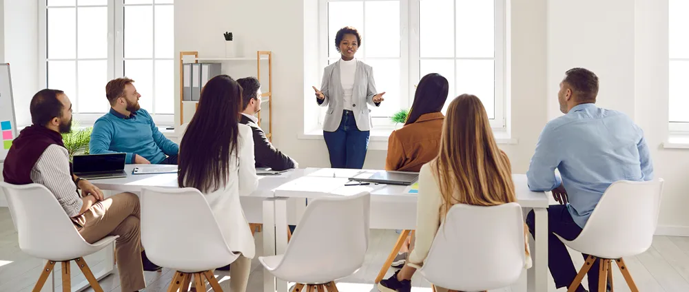Large team meeting around a conference table, representing an organization-wide enterprise software rollout