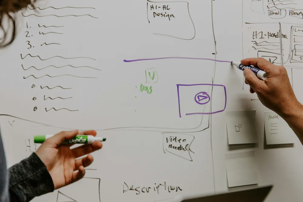 Two engineers planning small, sequential refactoring steps on a whiteboard