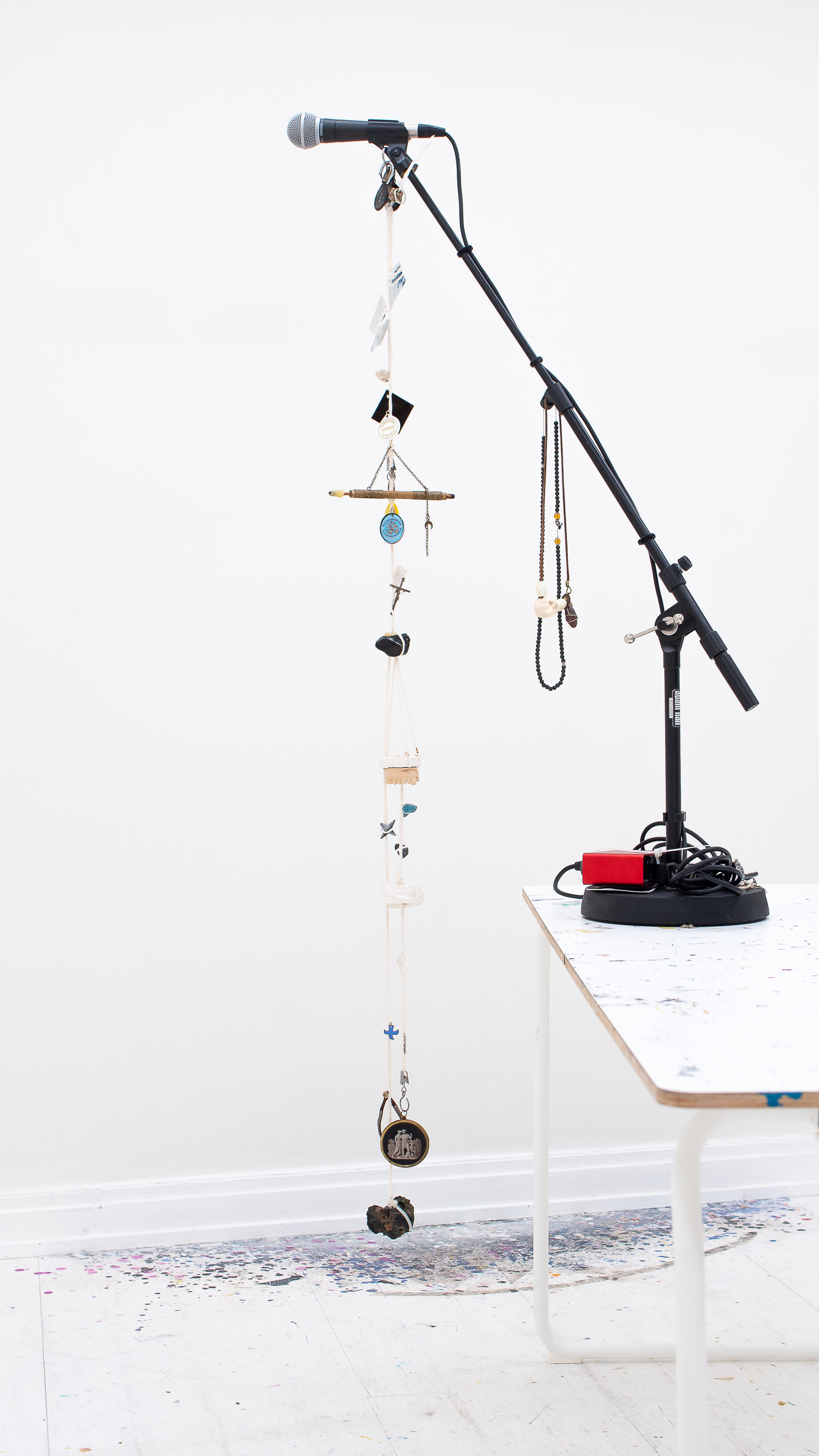 book spine.. variable dimensiones.. mic stand, feather, medals (ca), deer bone,.. engagement ring, porcelain fragments, plexi sample,.. aa symbol, indian keychain (om-symbol), cross (taizé),..  pipe steam (islamic crescent), crystals, crucifix, cast teeth