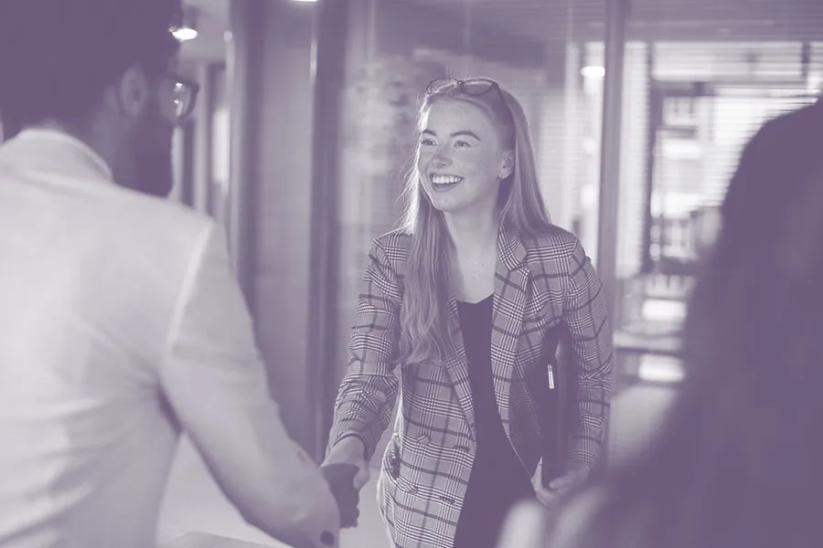 interview candidate shaking hands with recruiter in and office