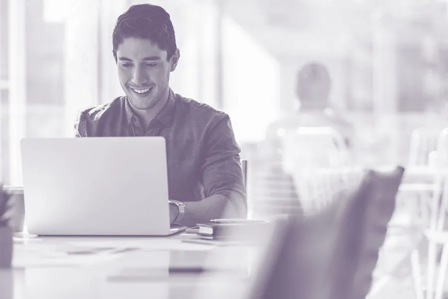 A man using a laptop computer in a modern office