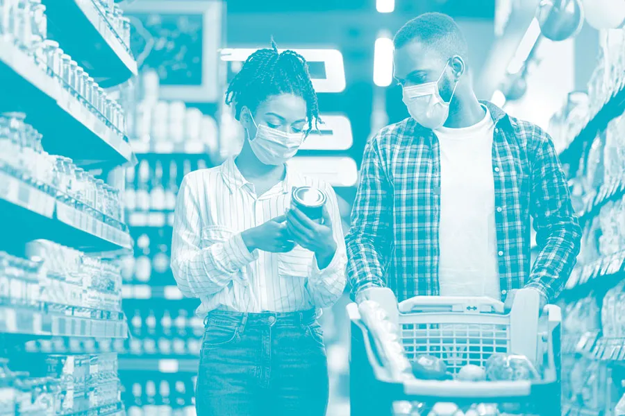 Couple grocery shopping with masks on