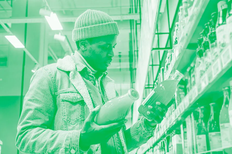 man comparing orange juice in grocery store
