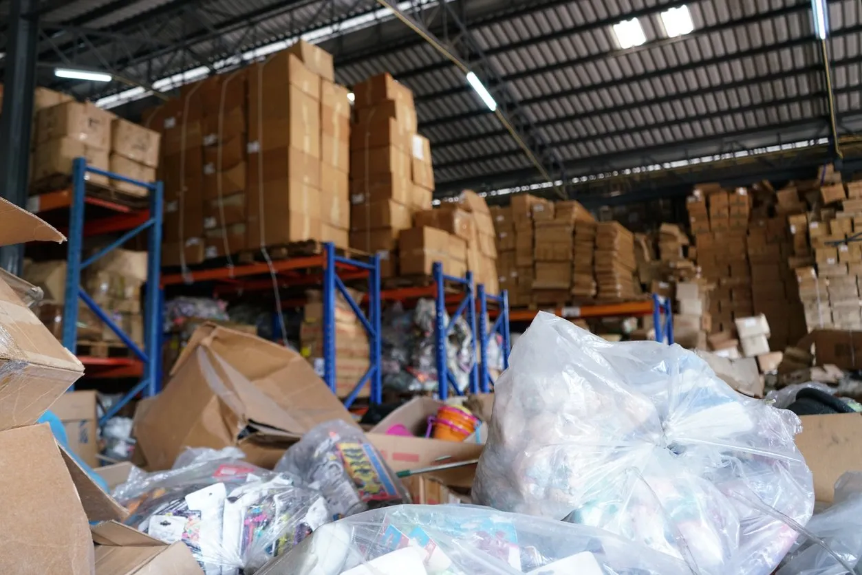 trash bags and crumpled boxes in a disorganized warehouse stock room