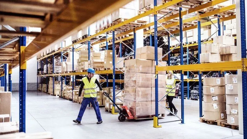 Warehouse workers pulling pallets of boxed excess cpg inventory for sale