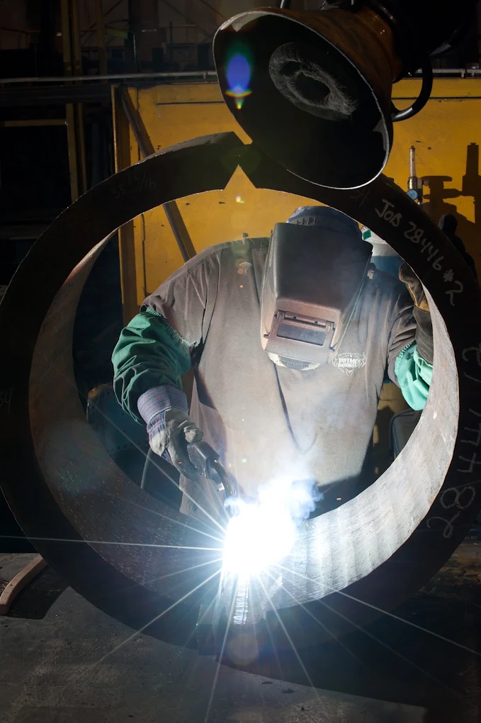 A JADCO welder working inside a rolled ring marked with its job number