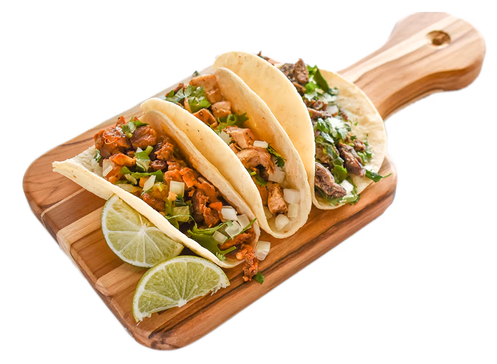 3 tacos and lime wedges on board