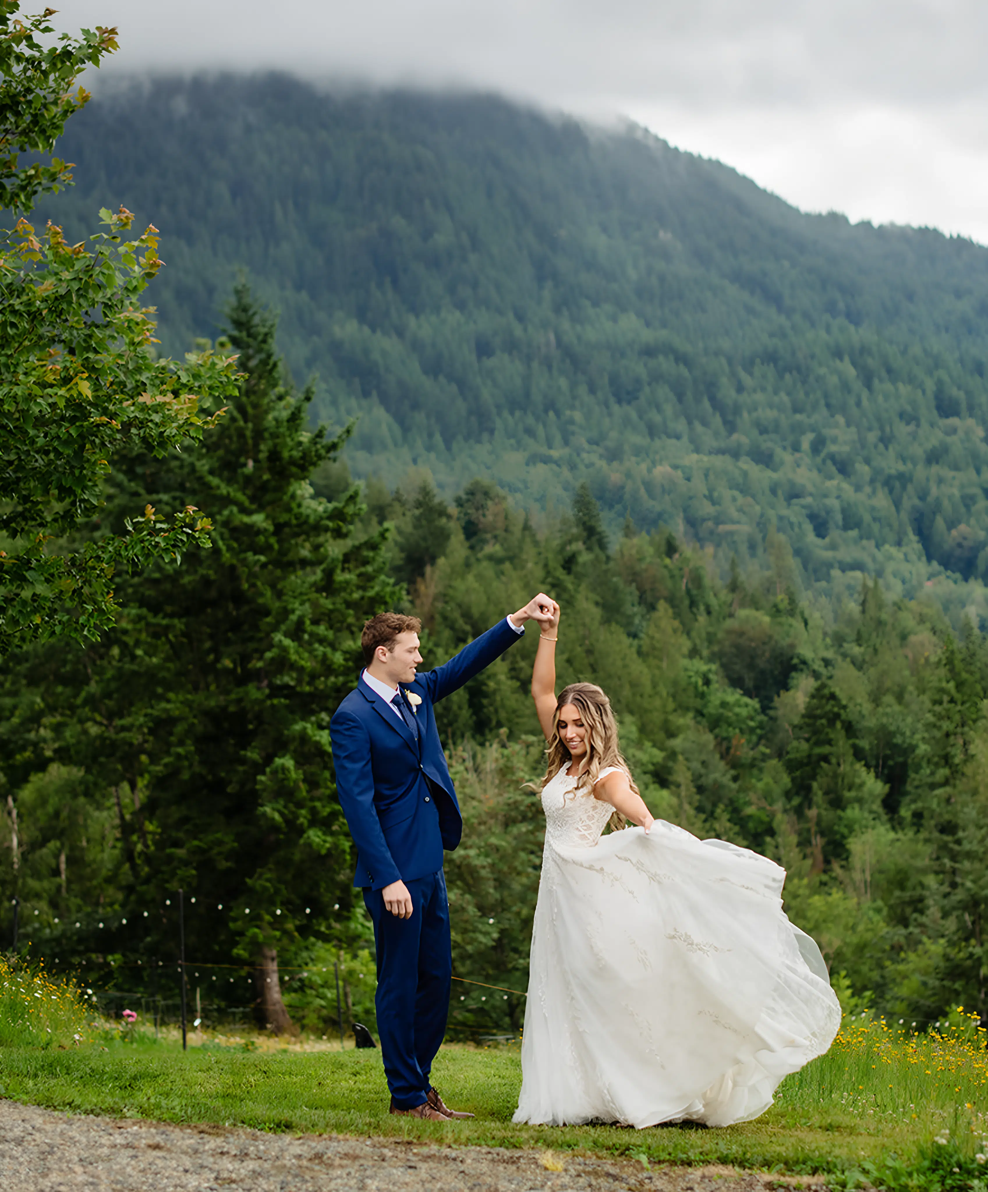 A bride and groom dancing in front of a mountain.