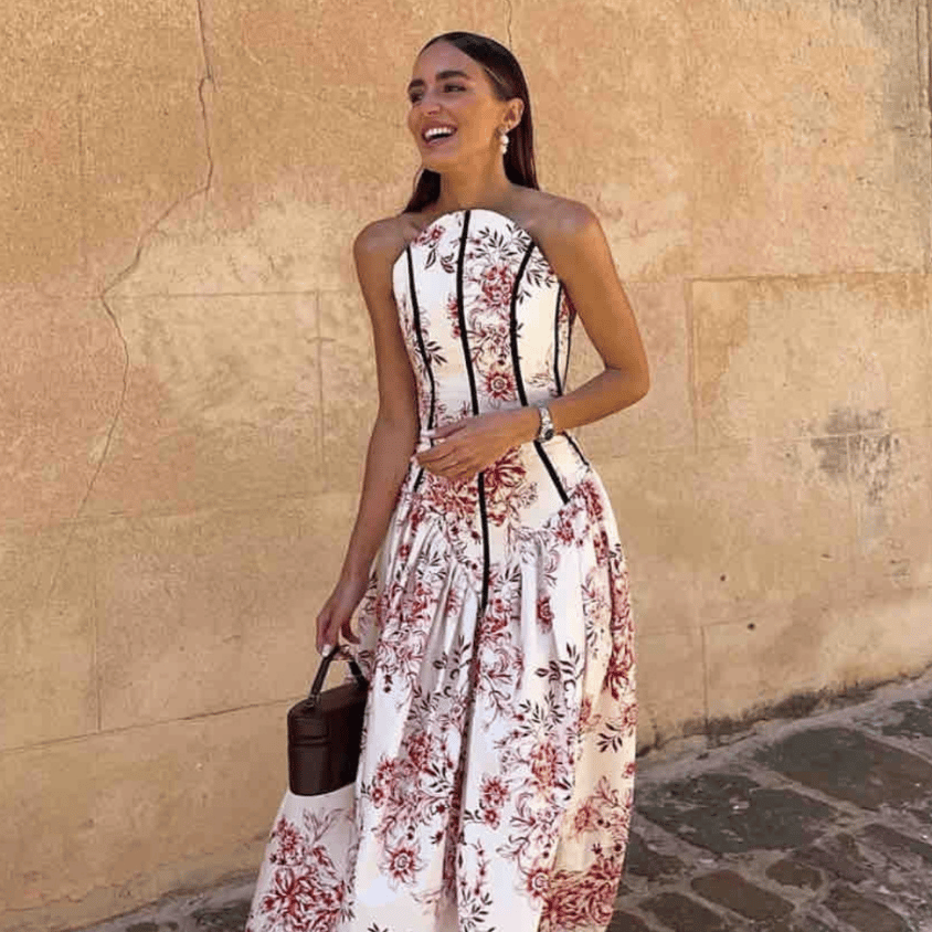 Vestido Clementina de The IQ Collection ideal para ser la invitada perfecta en bodas, bautizos, comuniones, graduaciones y todo tipo de eventos y ocasiones especiales. Vestido largo de palabra de honor con estampado floral en tonos rojizos. Parte superior tipo corpiño en la parte superior y vuelo en la parte baja. Detalle de bies en contraste en color negro. Cierre trasero con lazada.