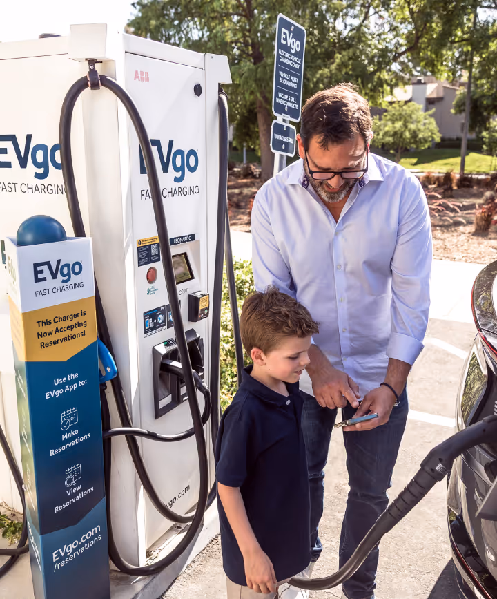Family charging their Kia at an EVgo fast charging station