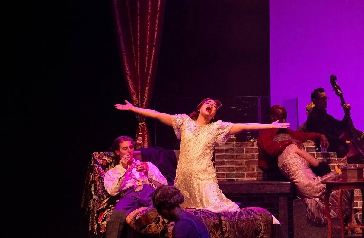 Ally as Nadine in The Wild Party, on stage, arms wide and mouth open mid-song.