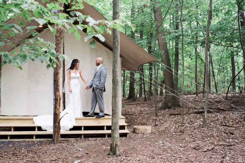 Bride and groom standing outside of bridal tent