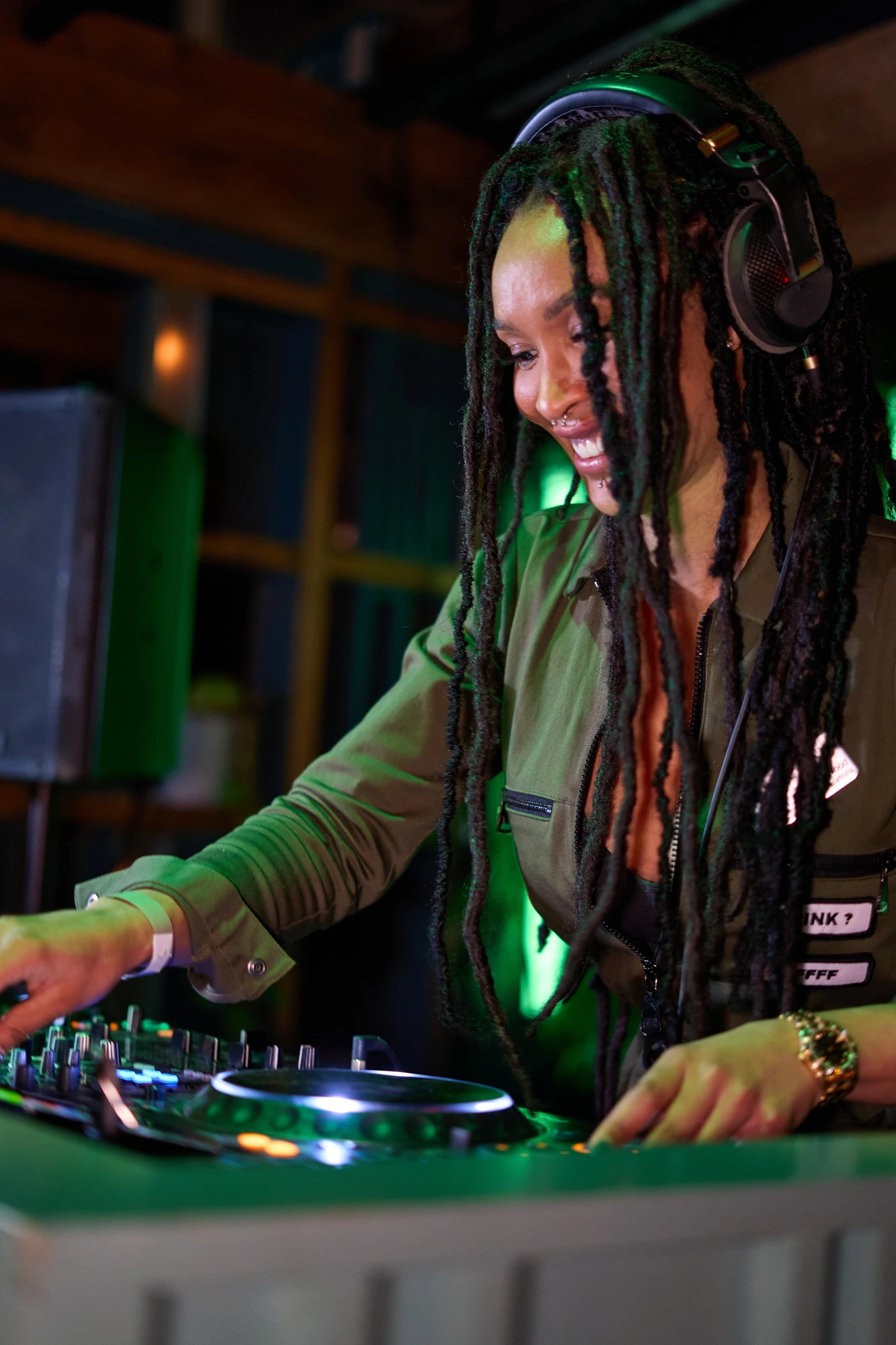 DJ Lady Roc wearing headphones and mixing music at the decks