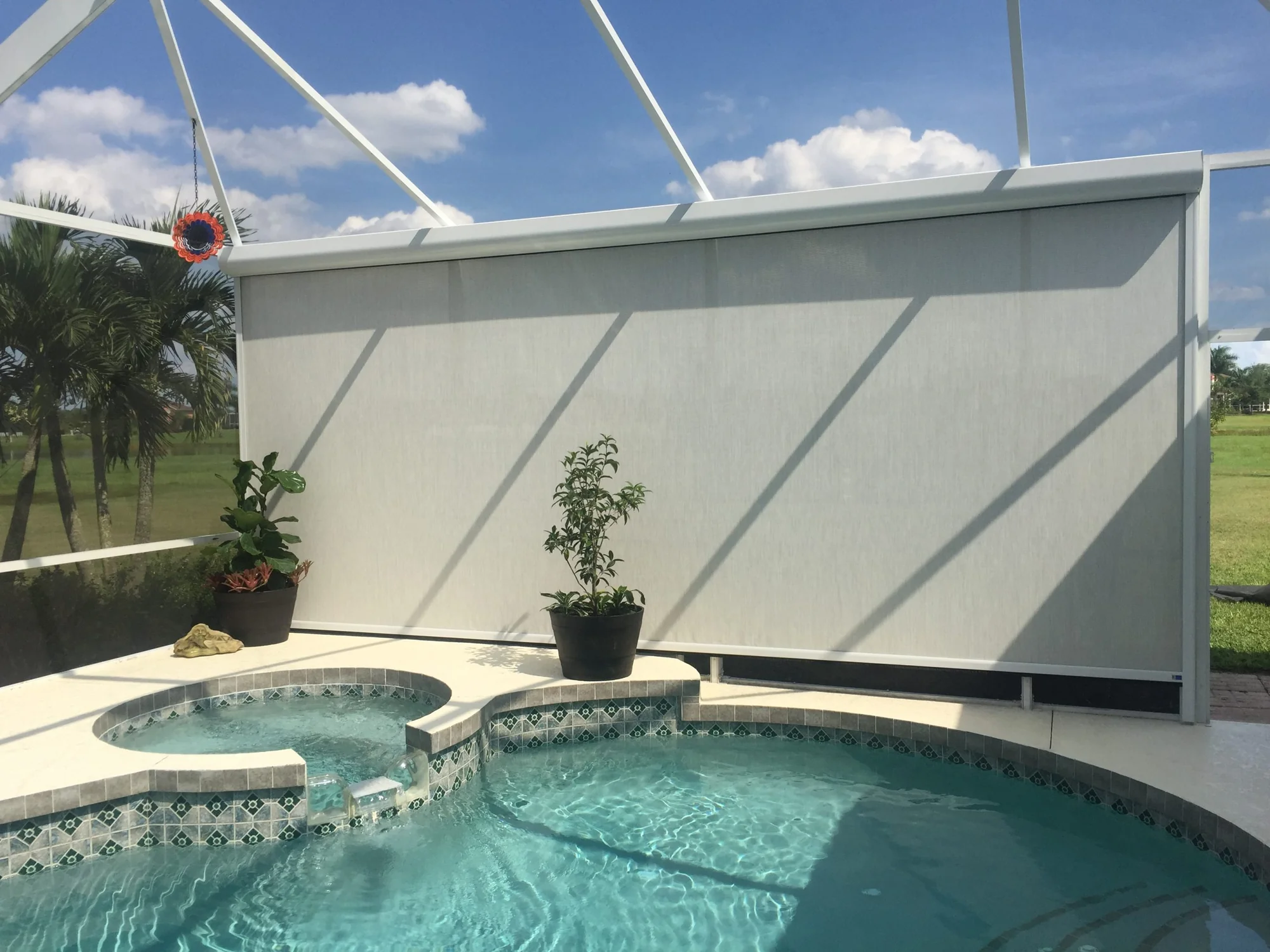 Motorized shade screen installation around residential pool cage