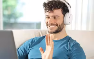Happy man having video therapy call on laptop at home. Teletherapy Makes Mental Health Support More Accessible UK?