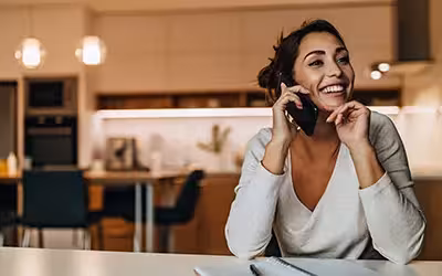 Women talking with someone over the phone. Your Guide To Getting A GP Referral In The UK